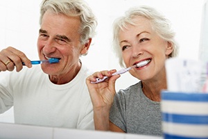 people smiling while brushing their teeth