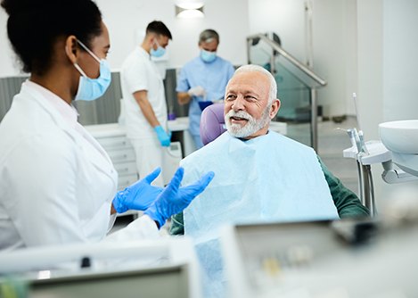 Older patient talking to oral surgery team member