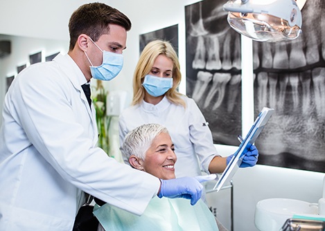 Patient looking at clipboard with dental team