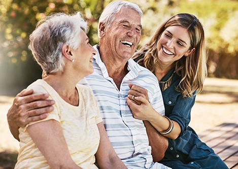 Happy senior man laughing with his wife and daughter